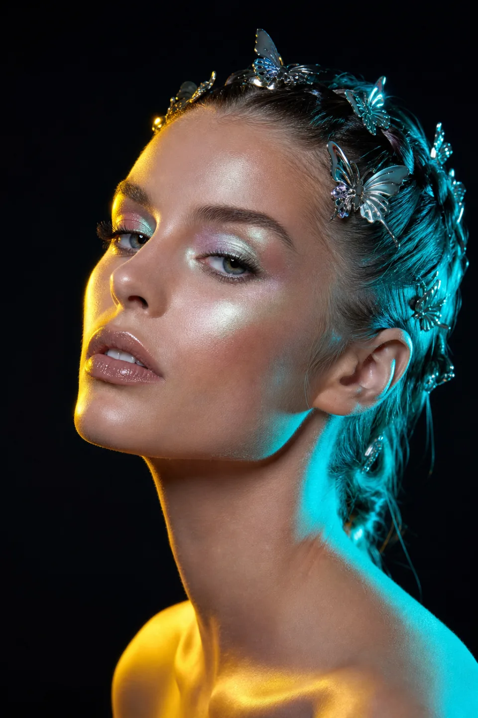 Editorial portrait with chrome butterfly hair accessories and neon lighting